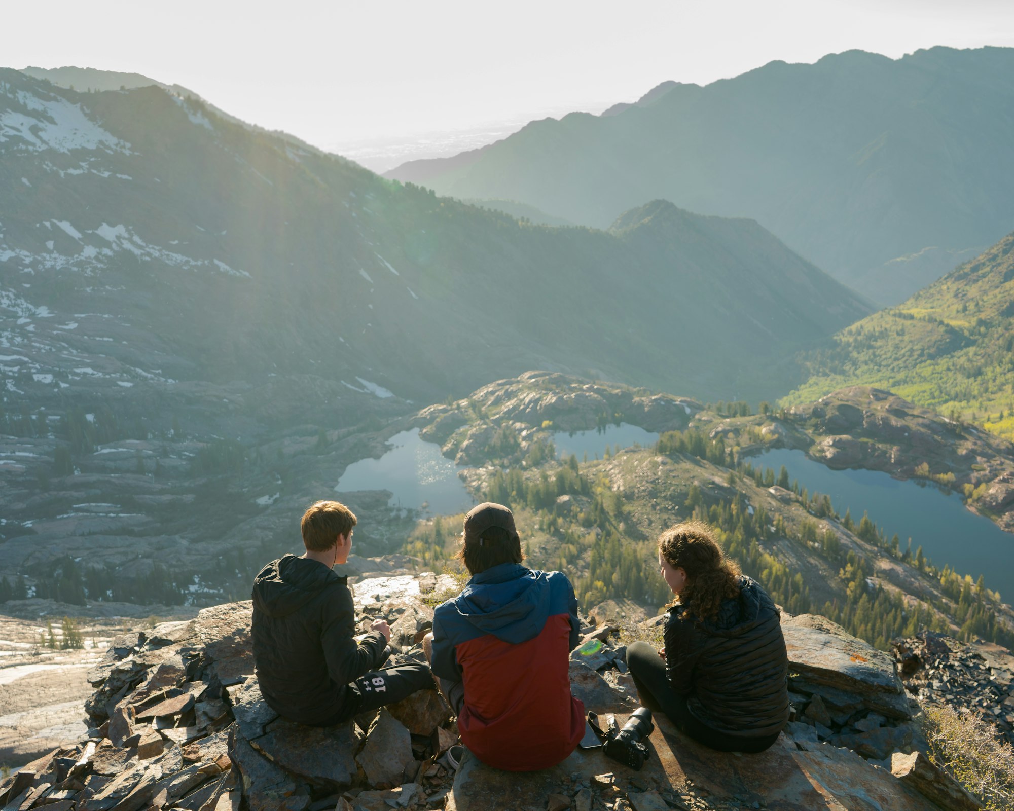 A family looking out over an alpine lake in the Utah mountains