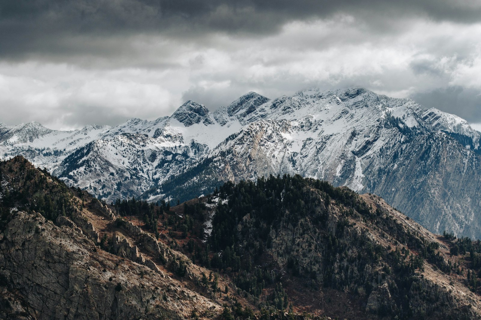 Snow-capped Wasatch range under a moody sky