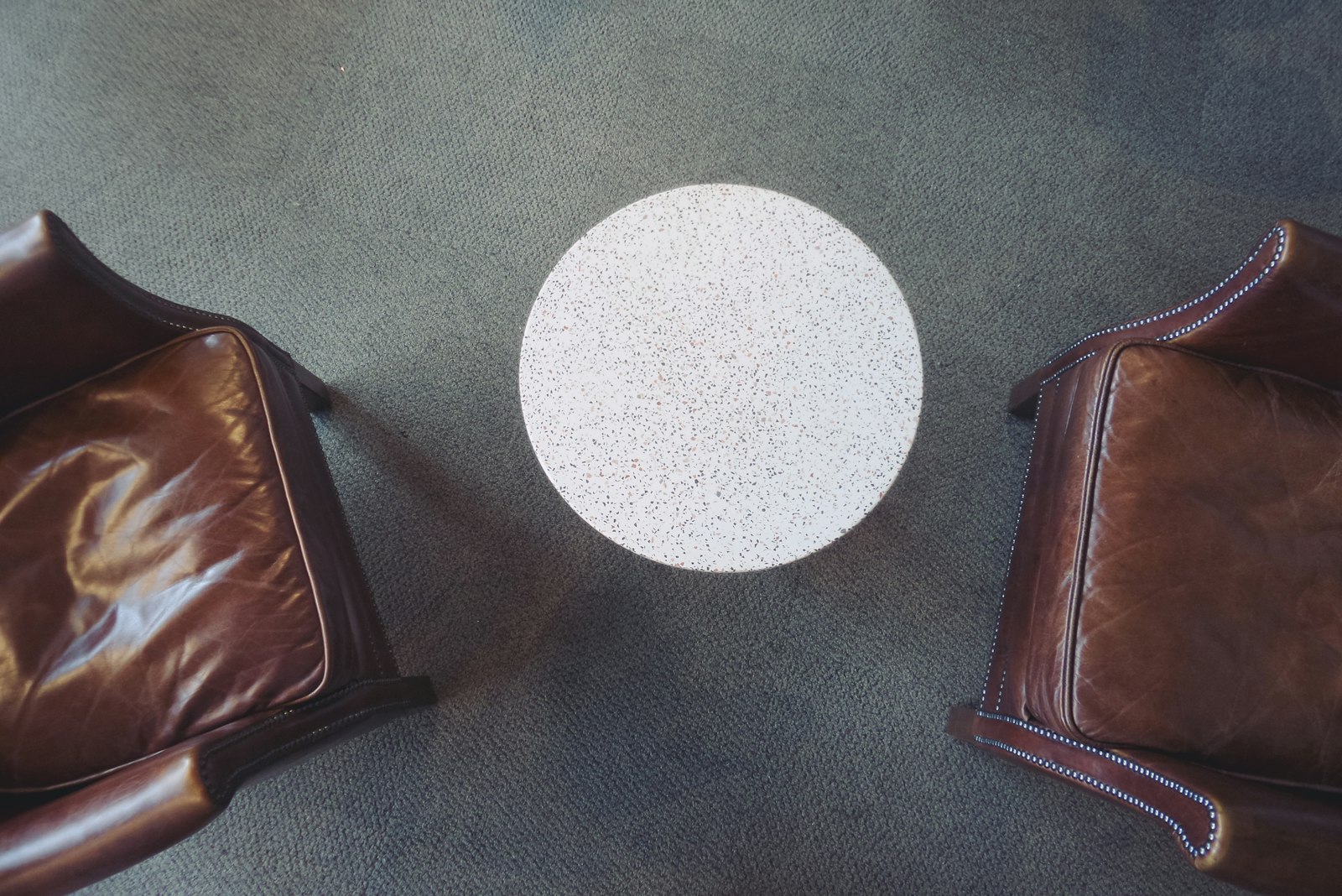 Two leather chairs facing each other across a small round table